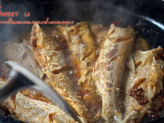 香辣刁子鱼,迅速将炸好的鱼下锅，轻微翻动，使鱼身均匀沾裹汤汁