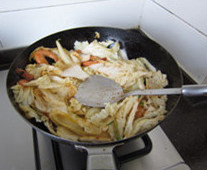 鲜虾炒白菜,下入葱姜蒜，煸炒出香味；下入白菜叶，转大火煸炒，一边炒一边用锅铲压白菜
