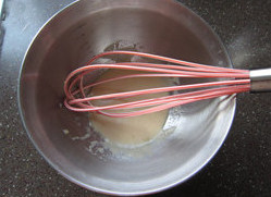 酸奶果仁小蛋糕,玉米油、酸奶、香草精一起放进大碗；用手抽使劲抽打至完全融合在一起，基本看不到油花