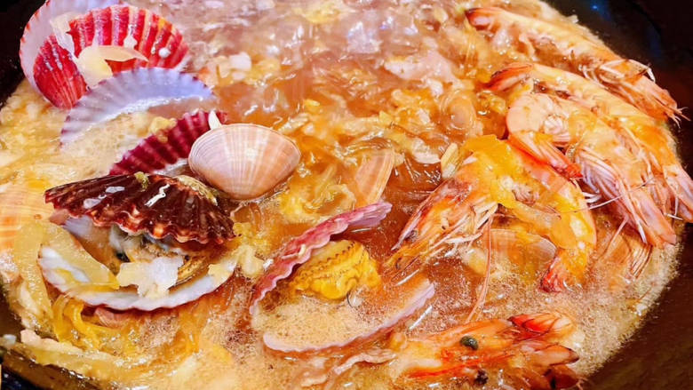 酸菜海鲜锅,放入海虾、蚬子、扇贝煮煮至开口熟透放入盐和鸡汁调味均匀