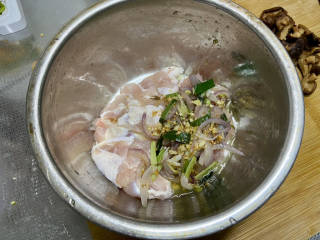 姜葱冬菇蒸滑鸡,把料头连油一起倒入鸡肉中