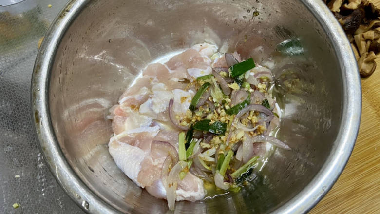 姜葱冬菇蒸滑鸡,把料头连油一起倒入鸡肉中