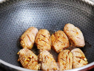 蒜香焖翅,锅中倒入少许食用油烧热，放入腌制好的鸡翅