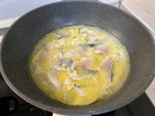 金汤鱼,再次煮开，保持小火一片片加入鱼肉，煮到鱼肉发白浮起