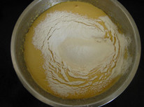红枣桂圆蛋糕,倒入煮红枣的水和油，从底部向上翻拌。再分三四次筛入混合的低粉和小苏粉，轻而快速的从盆底向上翻拌均匀。