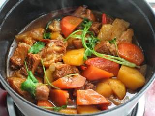 红烧羊肉煲,待肉质酥烂、土豆胡萝卜软糯，改大火翻炒收汁，撒香菜出锅即可。
