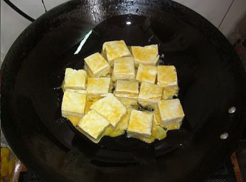 菠萝咕噜豆腐,锅内放入适量的油，烧热，放入挂好浆的豆腐块，小火煎至四面金黄，取出留底油备用