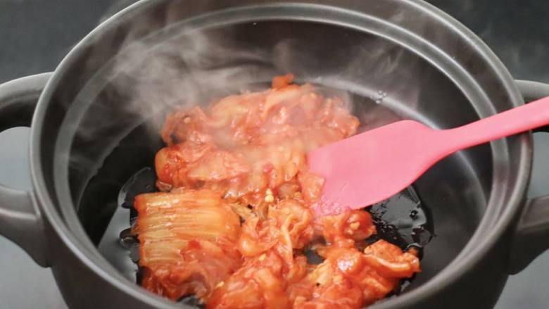 韩式年糕部队火锅,砂锅中倒入少许油烧热，先放入辣白菜炒香。