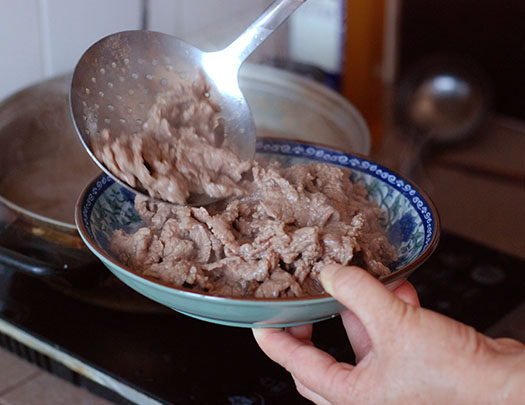 牛肉涮米酒,药五分钟后，捞出牛肉装盘，并倒入捣好的葱姜泥拌匀即可。
