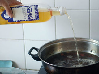 鸡肉涮米酒,倒入米酒，待汤水沸腾后，加入鸡肉。