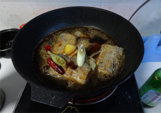 家常烧带鱼,把混合好的调料汁倒入煎好的带鱼里，炖制汤汁收浓，出锅之前撒上少许香菜。