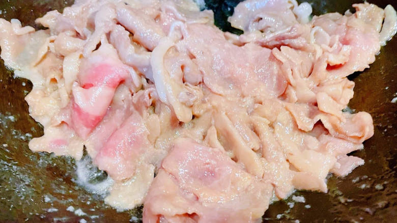 酸菜海鲜锅,锅中倒入底油加热放入肥羊片炒至变色