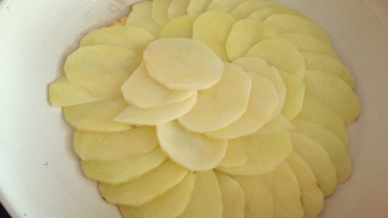 培根蘑菇薯片薄饼,刷一层<a style='color:red;display:inline-block;' href='/shicai/ 851'>橄榄油</a>，中火热锅，将土豆片铺在锅中（同一个方向扇形铺开）