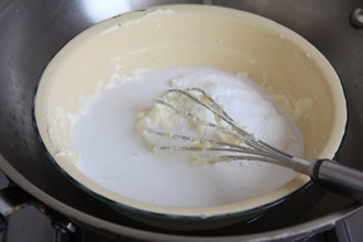 南洋风味的奶酪蛋糕——椰香奶酪蛋糕 ,材料B奶油奶酪在室温软化后，加细砂糖用隔水加热方式，用打蛋器搅拌使奶油奶酪呈无颗粒的光滑状，再分别加入椰浆和椰子粉，用打蛋器搅拌均匀。