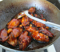 三杯鸡翅中,待鸡翅上色后，盖上锅盖，转中火，焖约3、4分钟,打开锅盖，大火收汁至汤汁全部收干