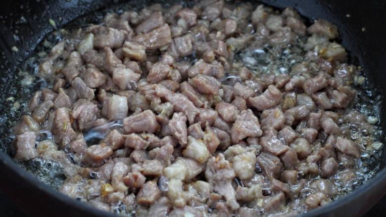 肉酱拌面,接着放入腌制好的肉丁，快速翻炒至发白断生状态。