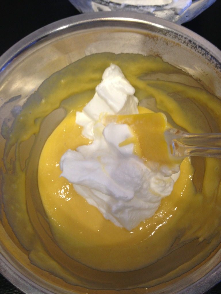 小C的芒果威风蛋糕,盛1/3蛋白到蛋黄糊中，用橡皮刮刀轻轻翻拌均匀，从底部往上翻拌，不要划圈搅拌，对免蛋白消泡；