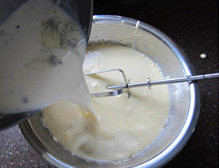 经典法式香草冰激凌,将锅中加热的牛奶奶油分两次加入蛋黄糊中，边搅拌边加入，第一次加入搅拌均匀后再加下一次，充分拌匀