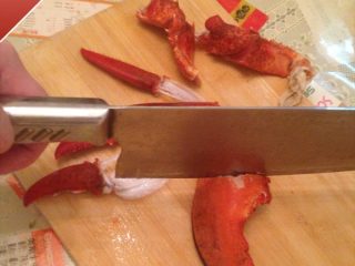 奶油芝士焗龙虾,接着将龙虾钳子从关节部位掰开，用手将小钳爪壳拽下来，用刀从大钳子中间处敲开钳壳
