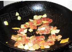黑椒苹果牛肉粒,取出苹果皮，把腌制好的牛肉粒滑入锅中，加入大蒜同时翻炒