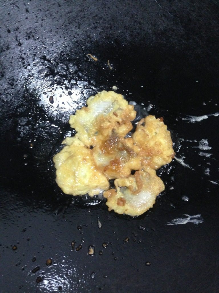 鲜炸豆腐鱼,如图锅内加油，将鱼炸至金黄，放入吸油纸上吸油。