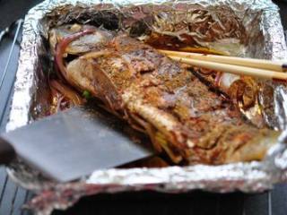麻辣烤鱼,烤好一面的鱼翻面后同样撒孜然、花椒、辣椒粉、橄榄油烤至金黄
