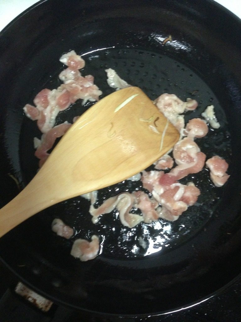 猪板筋炒茭白丝,如图锅肉下一点油，下猪板筋中火翻炒至肉条弯曲，肉色变后断生起锅。