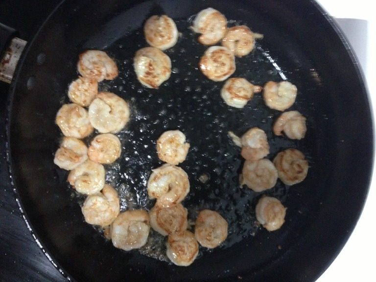 韭黄虾仁滑蛋,如图锅内放少许油，将腌制好的虾仁入锅炒至虾仁卷起。