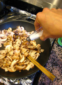 鸡肉蘑菇意面 ,放入蘑菇片，加入少许盐调味，翻炒到蘑菇变软