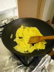 三色蛋炒饭,锅内放入少许油，油热后把蛋液倒入锅中，炒熟鸡蛋，并用锅铲把鸡蛋捣成碎块