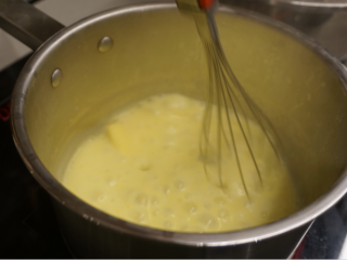 红丝绒蛋糕卷,用中火加热奶锅，并用手动打蛋器搅拌至黄油融化