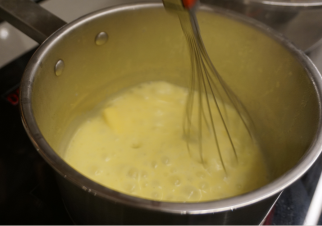 红丝绒蛋糕卷,用中火加热奶锅，并用手动打蛋器搅拌至黄油融化