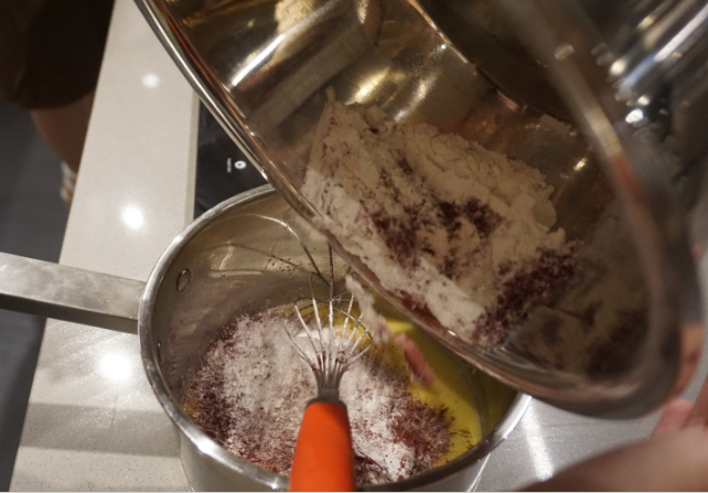 红丝绒蛋糕卷,把已过筛的粉类倒进奶锅里继续搅拌均匀