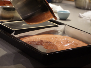 红丝绒蛋糕卷,把油纸铺好在烤盘里，从高处倒入搅拌好的面糊，刮平，然后震几下烤盘震出气泡