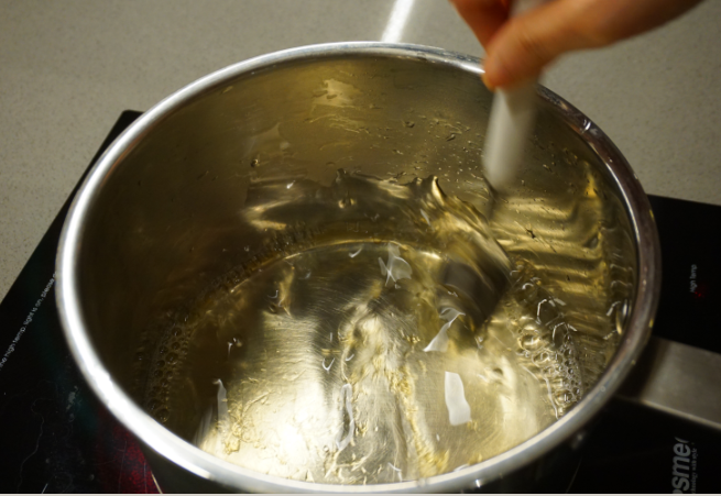 千层椰汁桂花糕,奶锅倒入水并小火加热，放进泡软的鱼胶片并搅拌直至完全融化