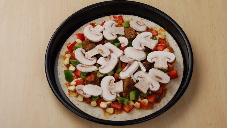 法式牛腩薄脆披萨,均匀的撒上青红椒玉米粒蘑菇片