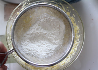 玫瑰饼干,加入低筋面粉，加入泡打粉，低筋面粉和泡打粉过筛到打发的黄油里