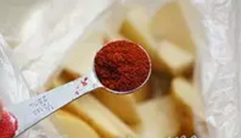 烤薯角,倒入红辣椒粉。
