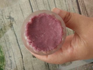 双色山药糕,最后取一个紫色圆球放进月饼模具中，用手稍微压扁。