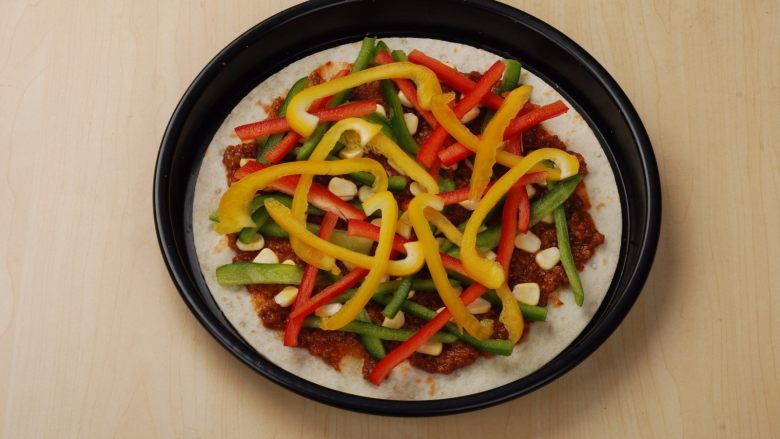 意大利肉酱缤纷薄脆披萨,青红黄椒洗净切丝后摆在食材上