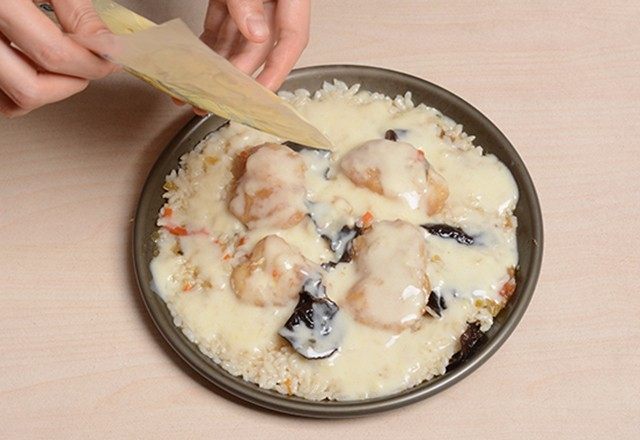 椒香鱼片铁盘焗饭,在表面均匀的撒上白酱