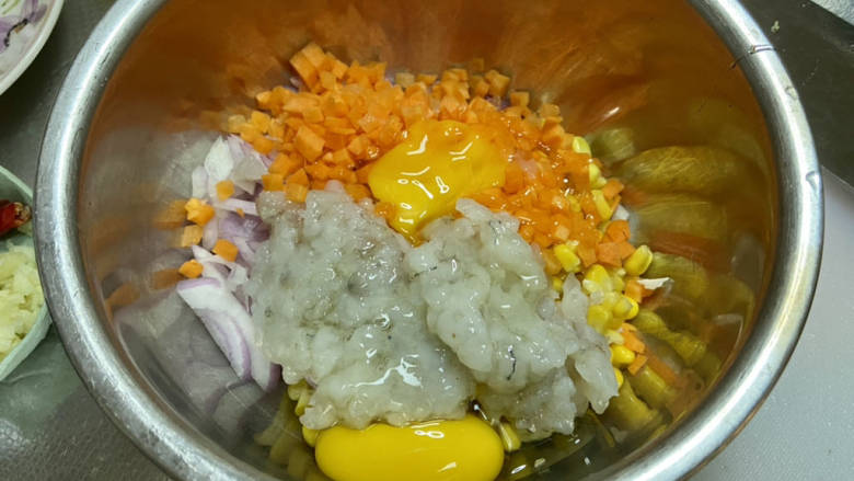 鲜虾蔬菜饼➕鲜虾洋葱胡萝卜玉米小饼,取一大碗，加入胡萝卜粒洋葱粒，虾肉粒，玉米粒，打入鸡蛋