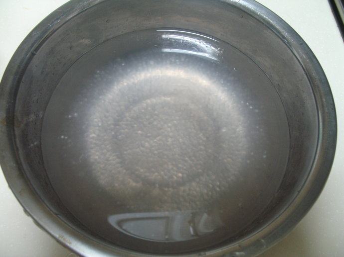 芒果西米露,锅里放水，水开后，放入西米，煮至西米呈透明状。并将煮好的西米放入容器中。