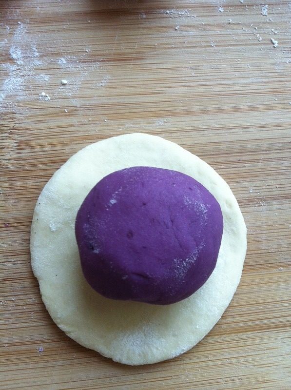 紫薯开花馒头,把白面团和紫薯面团分别分成20克左右的小面团，白面团擀成面皮，放上揉成小球的紫薯面团，包成团。也可以把紫薯面皮包白面团，做成的馒头也是很漂亮的。
