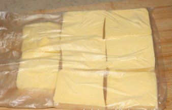 杏仁酥条,将裹入用的180g黄油切成小片，放入保鲜袋排好，用擀面杖把黄油压成厚薄均匀的一大片薄片