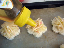 面包版奶酪苹果派,烤盘上刷上油，放入面包面片，撒上苹果丝，挤上蜂蜜