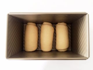 宝宝版拉丝超软吐司—一次发酵，快速方便！,将3个吐司卷，按同方向（卷的方向一致，把接缝处朝下）放入吐司盒内。
》卷吐司的环节，速度快的，三四分钟就可以搞定了。