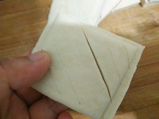 卤豆干,在白豆干的正面用刀斜着划出一些长口，注意不要切断。