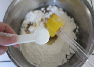 广式莲蓉蛋黄月饼,加入过筛后面粉的一半，加盐，搅拌均匀