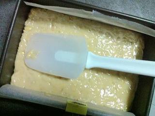 花生牛轧糖,迅速倒入准备好的模具中，用一只干净的刮刀把锅里和勺子上的糖浆刮干净，并把牛轧糖压平整